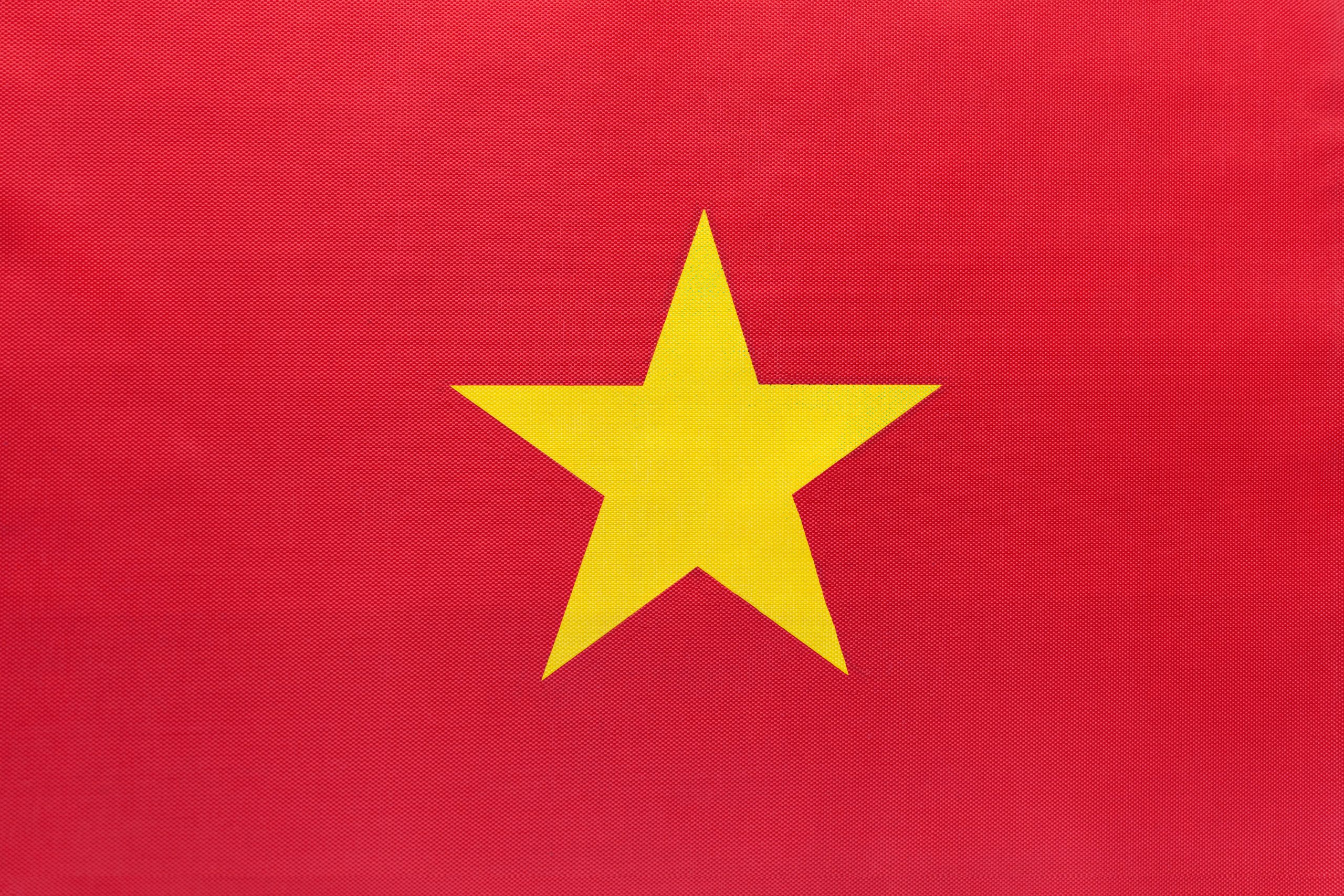 Vietnam national fabric flag with emblem, textile background. Symbol of international world Asian country. State official vietnamese sign.